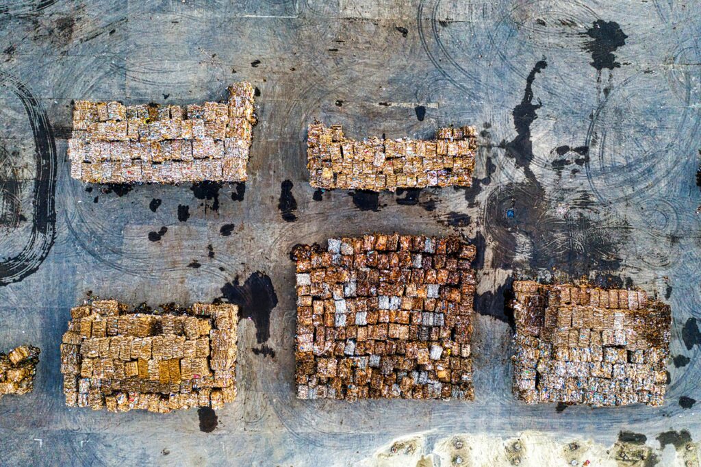 Aerial shot of organized recyclable material stacks in Serang, Indonesia, highlighting waste management efforts.